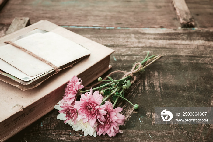 Vintage novel books with bouquet of flowers on old wood background - concept of nostalgic and rememb