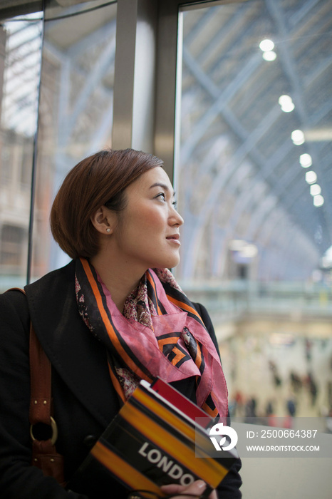 英国伦敦圣潘克拉斯车站年轻女子拿着旅游指南