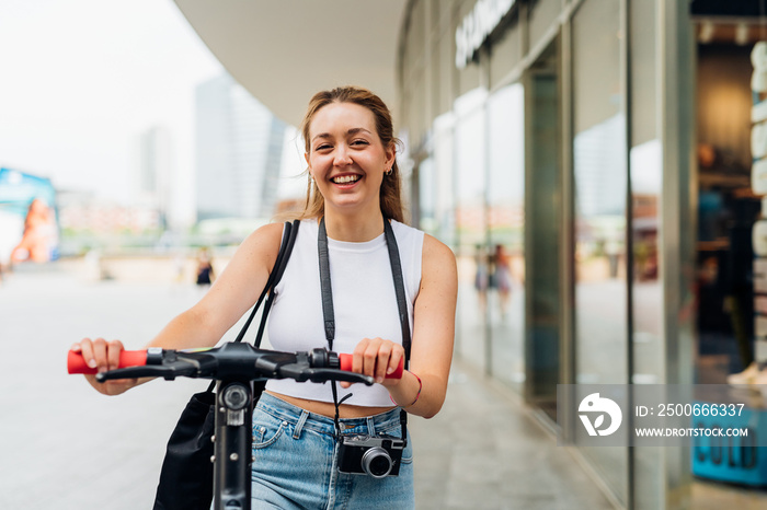 Young caucasian smiling woman outdoor riding kick scooter enjoying green living and sustainability