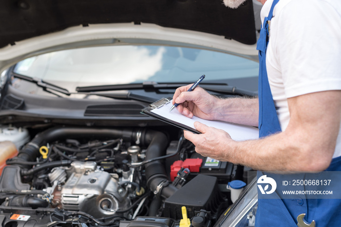 Car mechanic checking a car engine