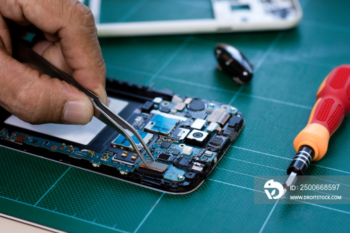 技术人员手工使用焊料修理和组装移动智能手机主板