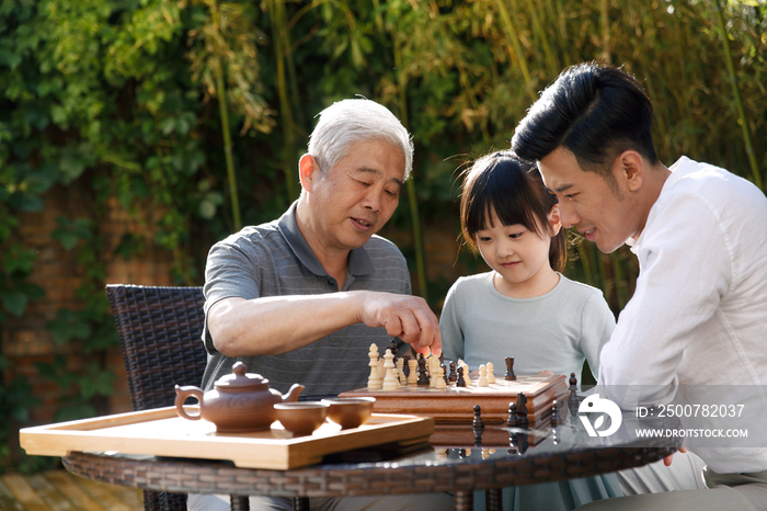 祖孙三代在庭院里下棋