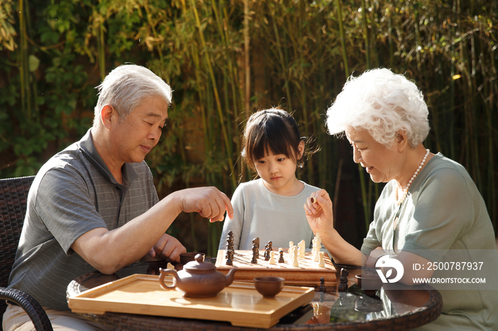 老年夫妇和孙女在院子里下棋