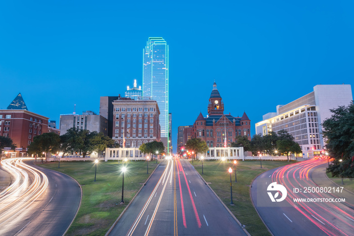 Dallas skyscrapers and light trail traffic over Dealey Plaza, JKF assassination site. Skyline and transportation cityscape at twilight