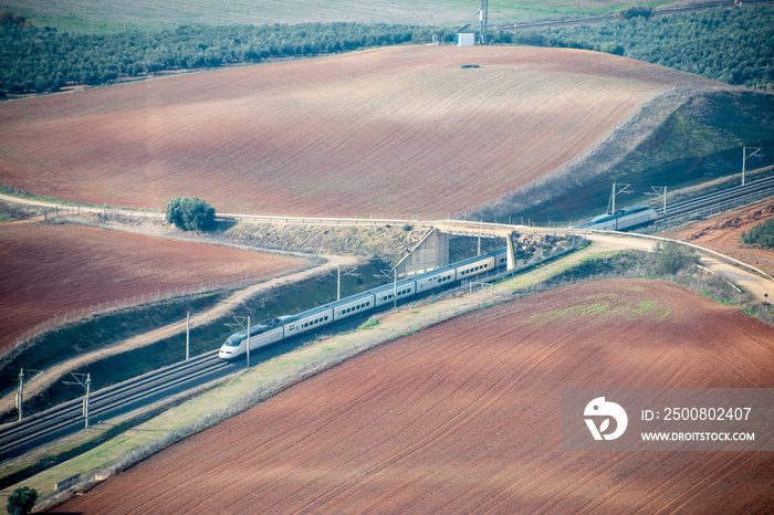 A Spanish highspeed train traveling through the Almodovar countryside at speed