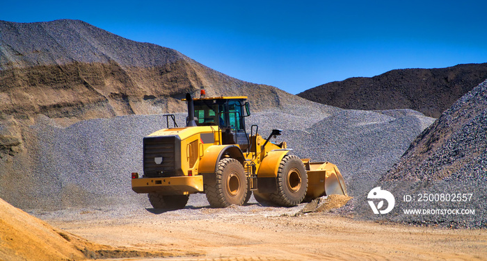 Maintenance of yellow excavator on a construction site against blue sky. repearing wheel loader at sandpit during earthmoving works