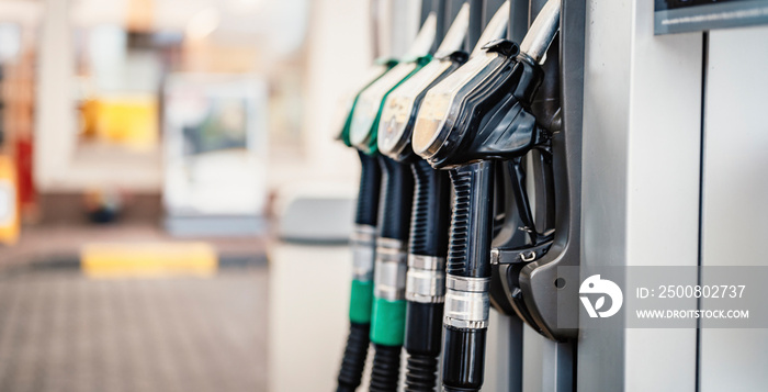 Closeup of woman pumping gasoline fuel in car at gas station. Petrol or gasoline being pumped into a motor. Transport concept