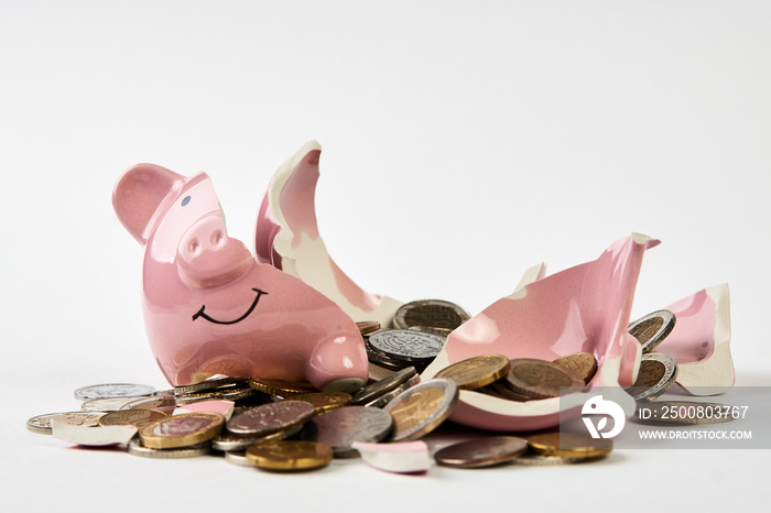 Broken piggy bank with coins money isolated on white background, close-up