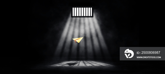 Freedom Concept : Yellow paper plane flying in prison inside interior with sunlight lighting through window in dark room.