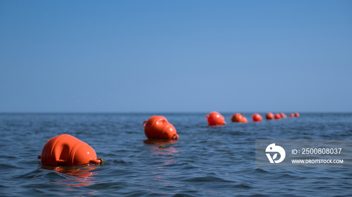 Orange floating buoys in the sea. Human life saving concept. Blue sky.