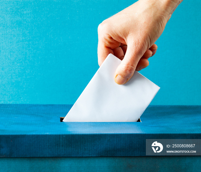 european Union parliament election concept - hand putting ballot in blue election box