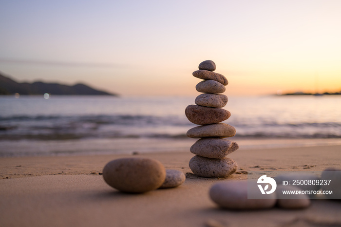 Zen stones on the beach in sunset time