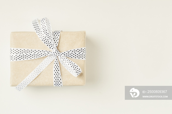 Wrapped gift box with ribbon bow on a white background, copy space