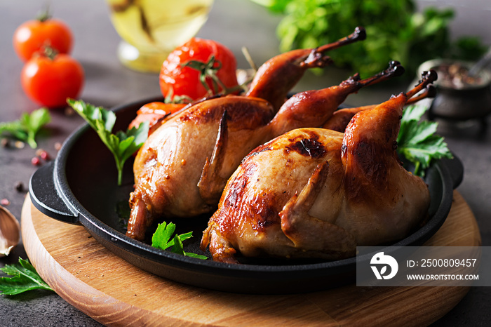 Baked quails in pan on a dark background