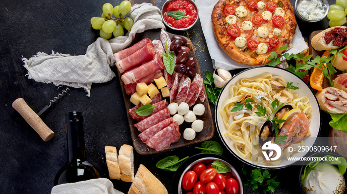 Italian food dishes on dark background.