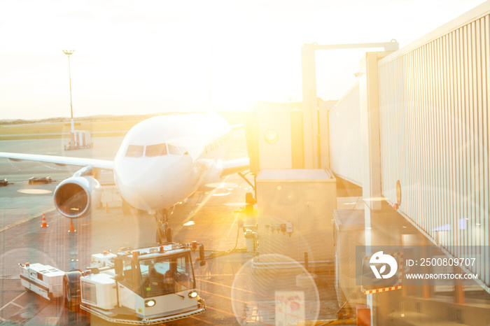 Modern international aerport travellers, airplane through airport window view on summer sun background