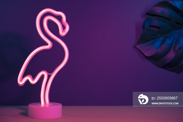 Summer pink flamingo and monstera leaf with neon pink and blue light.vacation background.