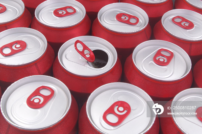 Many closed red drink tin cans as background, one can opened.