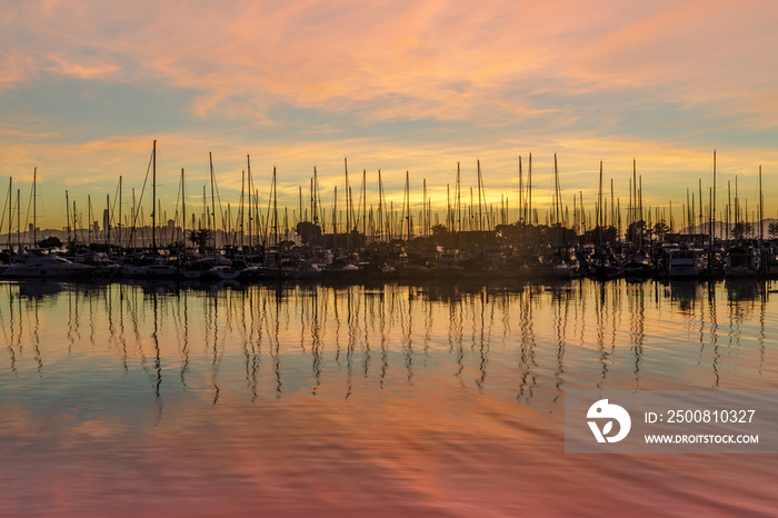Colors of Emeryville Marina. Sailboats moored in San Francisco Bay with sunset skies and water reflections. Alameda County, California, USA.