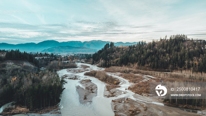 Arial / drone shot of Chilliwack river / Vedder river with mountains, forest, trees and clouds in the background, located in Chilliwack BC Canada near Vancouver, Abbotsford and Hope.