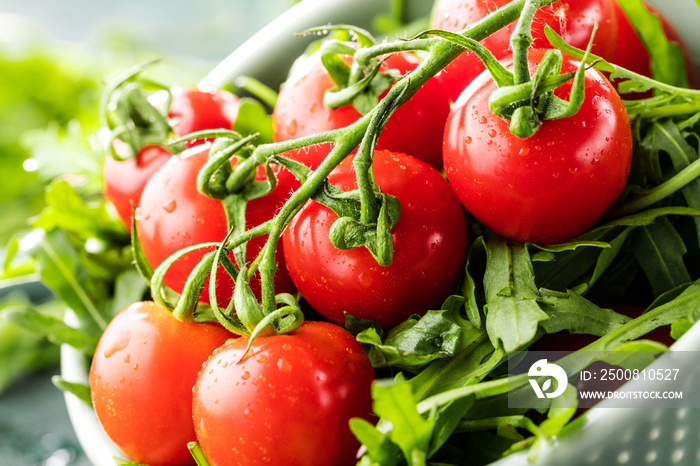 Frische kirschtomaten mit wassertropfen und ruccola salat