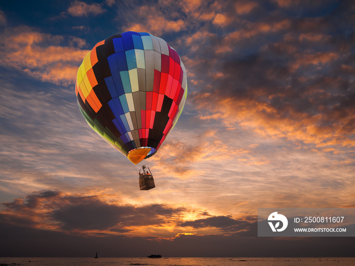 Hot air balloon over the sea at sunset