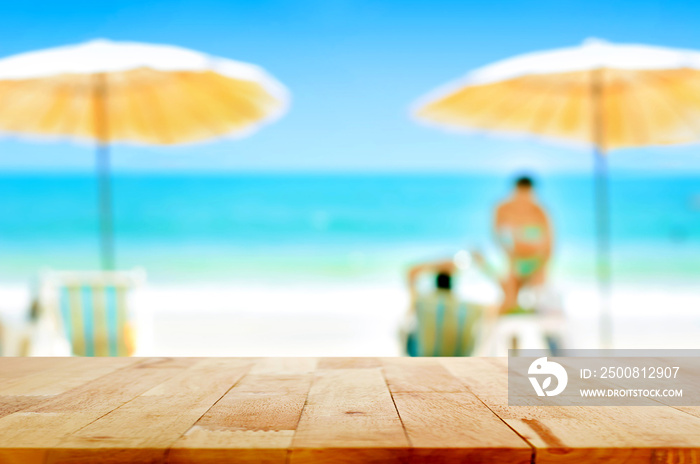 Wood table top on blurred white sand beach background with some people