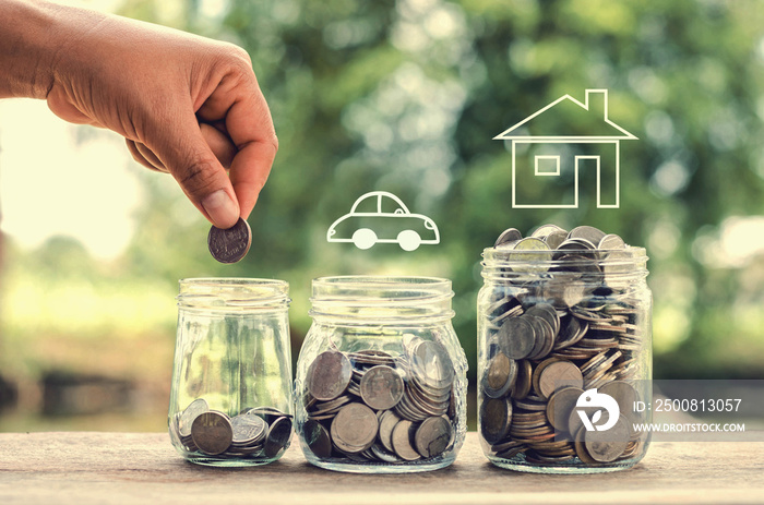 female hand putting money coins in glass jar  concept saving for buy home and car