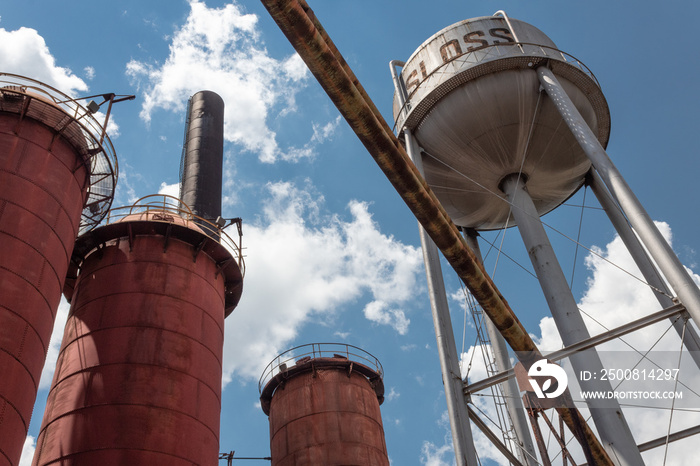 Sloss Furnaces National Historic Landmark, Birmingham Alabama USA, view looking up at water tower and furnaces against a blue sky with clouds, horizontal aspect