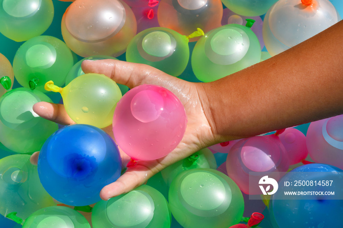 Person holding a handful of colorful water bombs