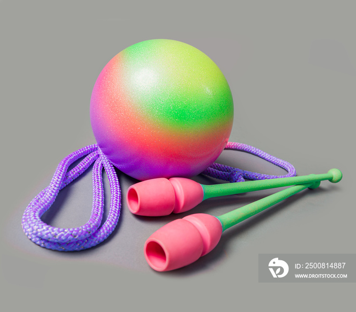 Rhythmic gymnastics equipment on grey background. Green ball, mace and rope for gymnastics.