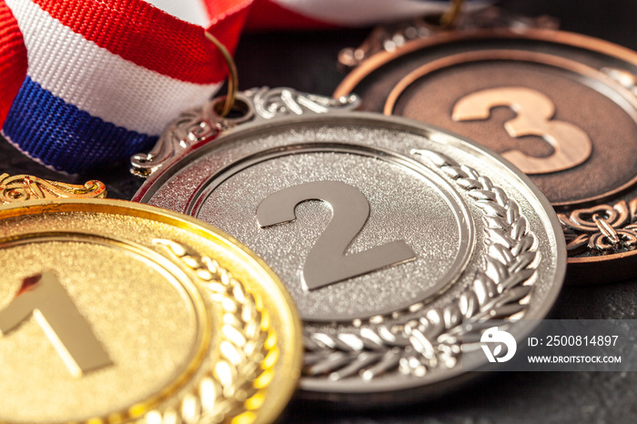 Gold, silver and bronze medal with ribbons. Award for first, second and third place in the competition. Prize to the champion. Black background