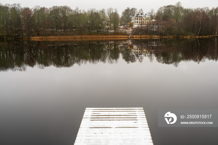 Lake with a mansion on a hill and water reflection