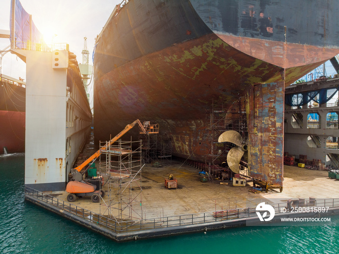 Cargo container ship stern with propeller at dry dock for maintenance follow annual plan and service.