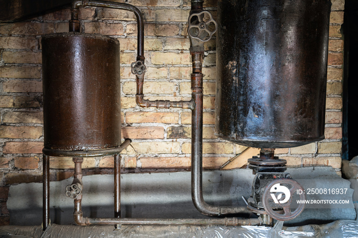 Rusty boiler room pipes. Old metal boiler generating heating and delivering it to home through pipeline. Hot water or gas is being delivered with this system