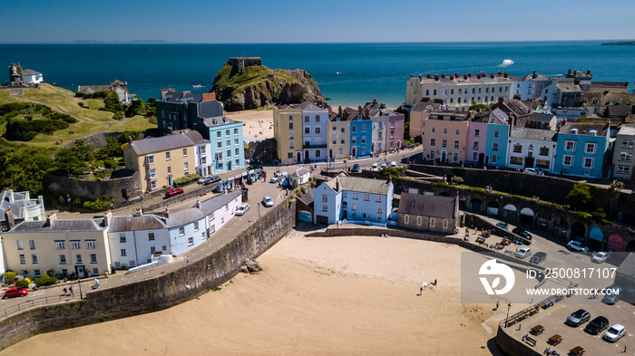 Aerial drone view of colorful buildings next to the ocean in a picturesque seaside town (Tenby, Wales, UK)