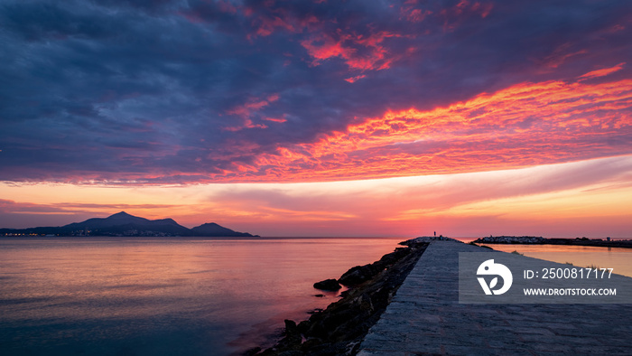 Majorca Puerto de Alcudia beach at sunrise in Alcudia bay in Mallorca Balearic islands of Spain. Sun rises near the mountains in the sea