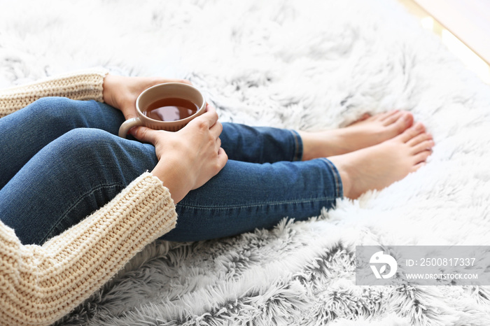 Young woman drinking hot tea at home