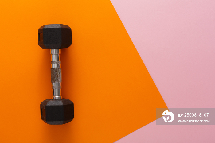 Dumbbell on orange background top view