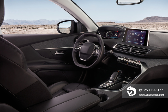 Cockpit of a modern SUV with a view of the desert and mountains. In the mirror you can see the road on which it stands.