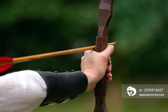 Archer holds his bow aiming at the target. Archery competition, outdoor activity