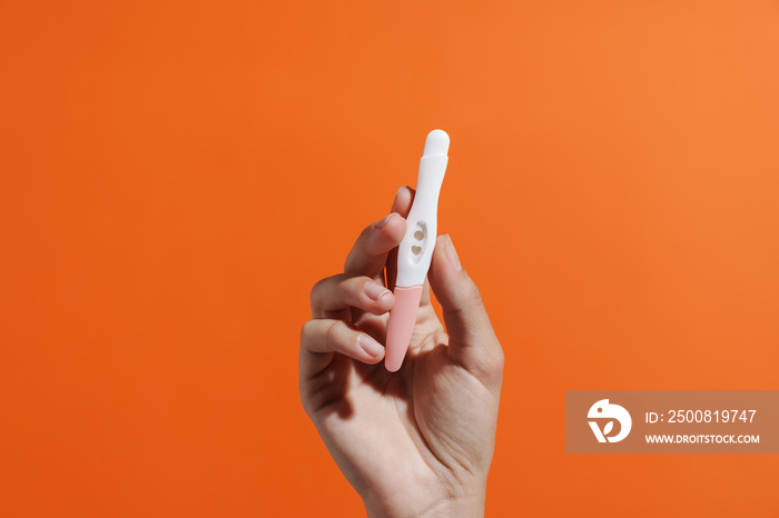 Woman’s hand holding pregnancy test