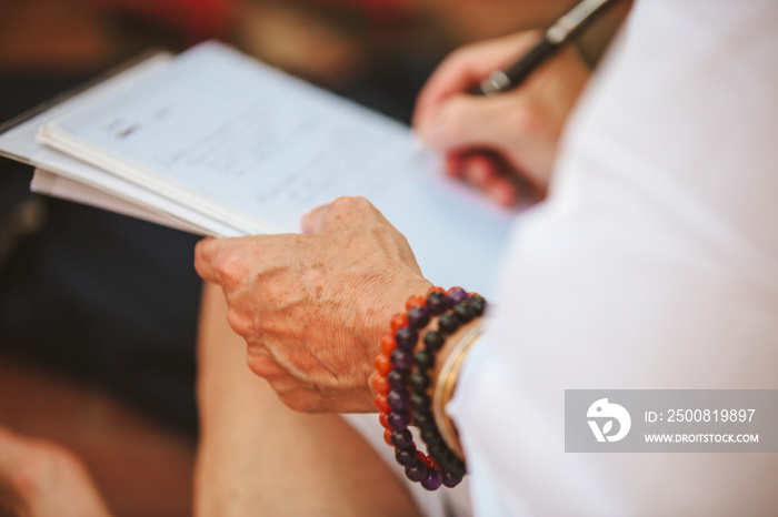 Older woman’s hand taking notes