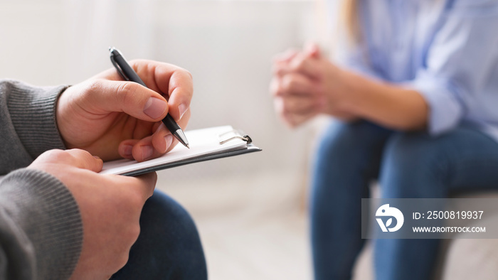 Psychologist noting problems of patient at therapy session