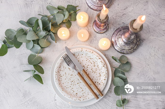 Beautiful table setting with burning candles and floral decor