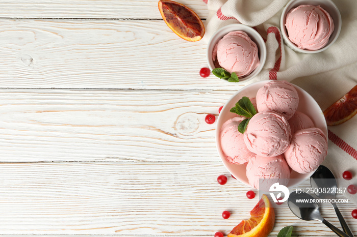 Bowls with ice cream balls on white wooden table, top view