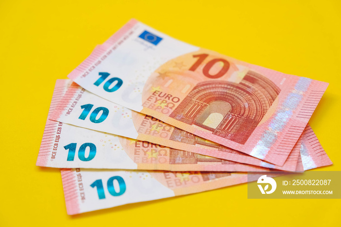 Euro banknotes on a yellow background. Copy, empty space for text