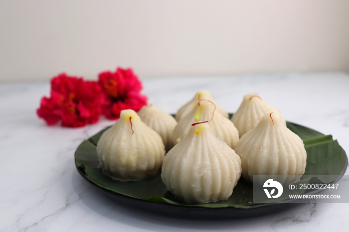 Steamed or ukdiche Modak. It’s a traditional sweet dish made out of coconut, jaggery and dry fruits stuffed inside rice dough. Offered to Lord Ganesha during Ganpati festival in India. with copy space