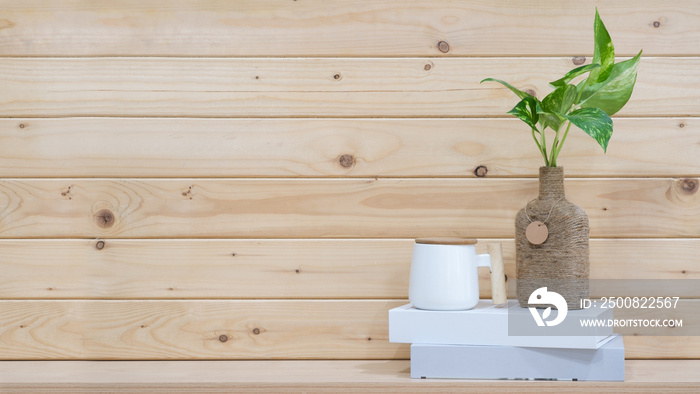 Books on wooden table with green leaf and wooden wall background empty copy space for text. minimal Workspace desk.