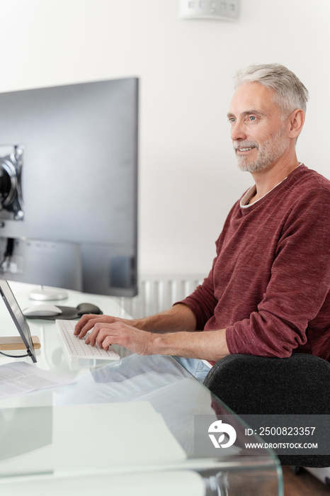 Mature man working on computer at home